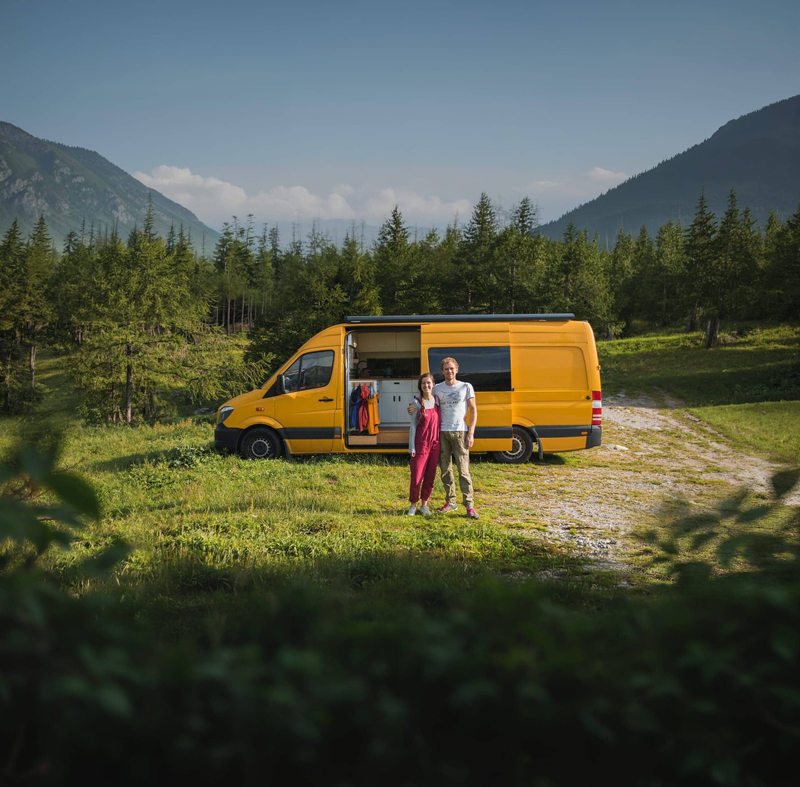 Gele camperbus in berglandschap
