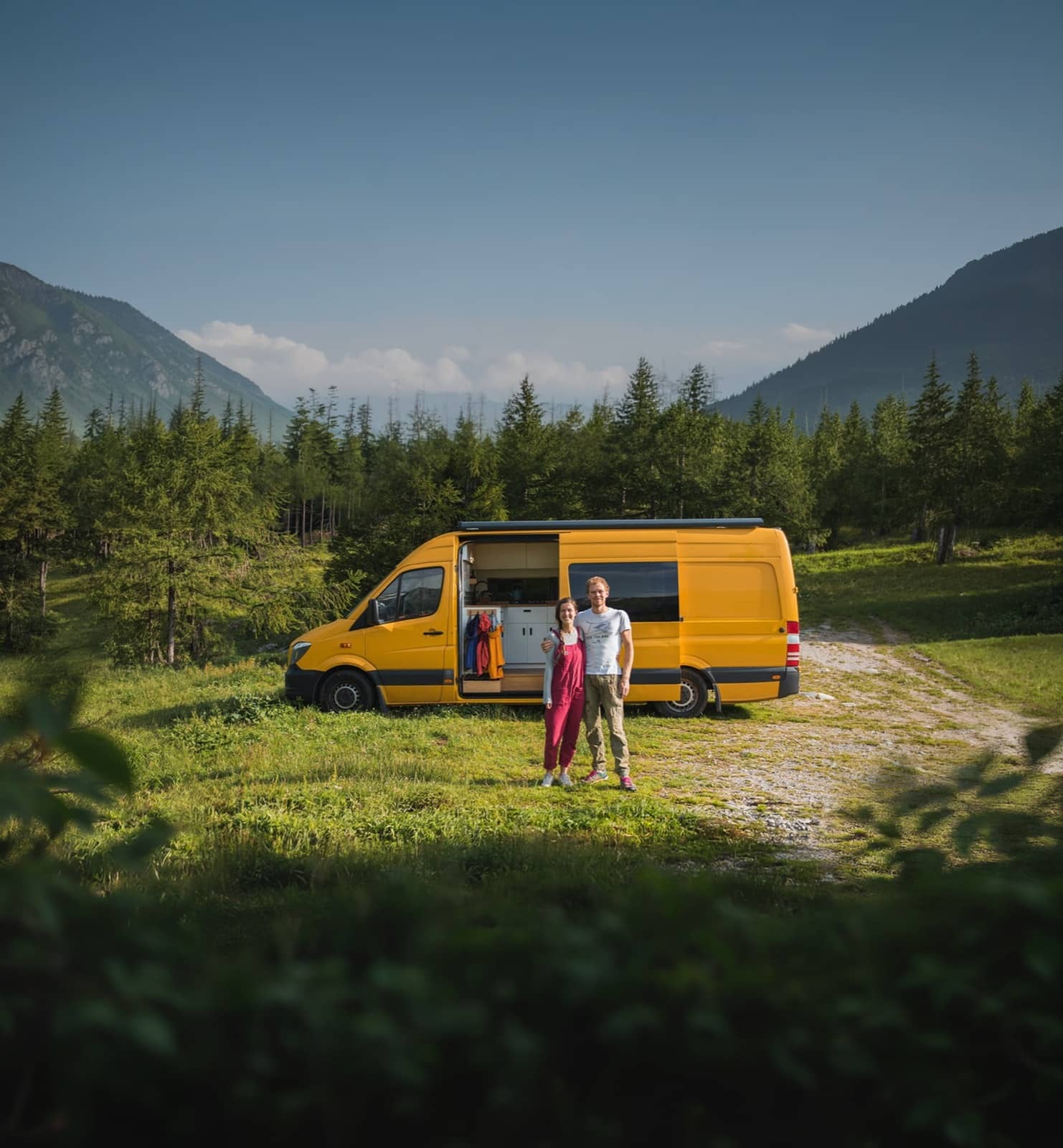 Gele camperbus in berglandschap