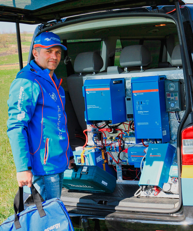 Een Victron professional naast een auto met Victron apparatuur in de achterbak